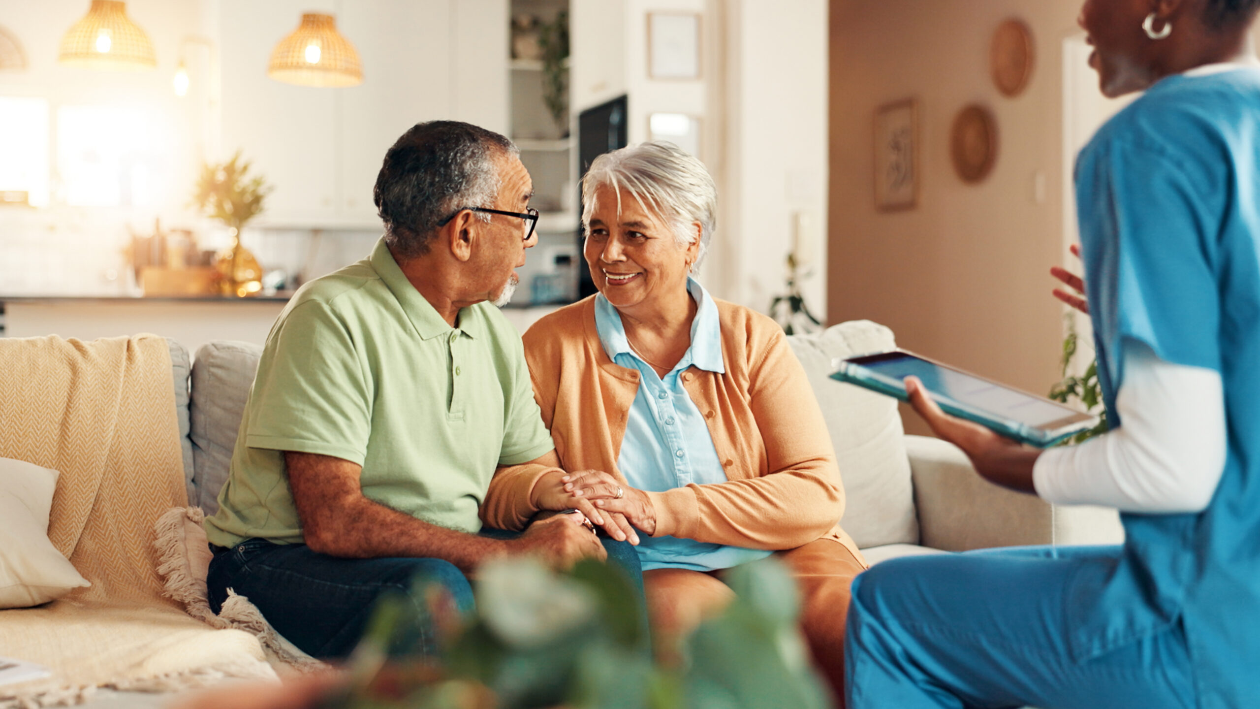 Nurse, senior couple and tablet in home for report with medical results, feedback or happy for good news. Caregiver, elderly man and woman with digital touchscreen, app or consultation in retirement